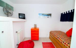 a small bedroom with a bed and a red dresser at Excellent Golden Apartment in Cabanas de Tavira