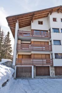 um edifício com portas de madeira na neve em Chesa San Gian - Celerina em Celerina