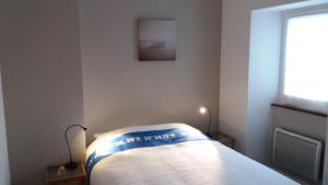a bedroom with a bed with a picture on the wall at Lesneven Appart Nuitee in Lesneven