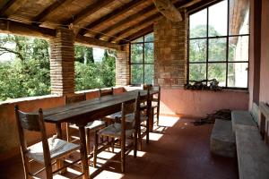 a dining room with a table and chairs and windows at Antico Giuncheto in Magione