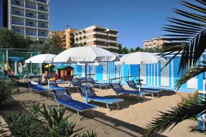 - un groupe de chaises longues et de parasols à côté de la piscine dans l'établissement Clipper, à Pesaro