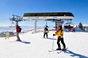 a group of people on a ski lift in the snow at Résidence Goélia Le Domaine de Castella in Font-Romeu