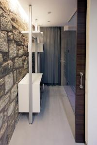 ein Badezimmer mit einer Steinmauer und einem weißen Waschbecken in der Unterkunft Hotel Restaurante Masía la Torre in Mora de Rubielos + 37 Fotos