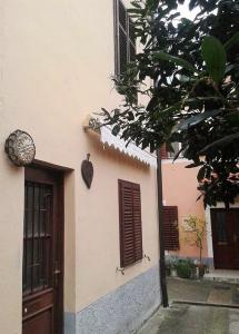 a building with brown shutters and a door at Apartma Izola in Izola