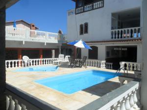 a swimming pool in front of a building at Pousada Pratagy in Saquarema