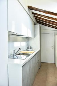 eine Küche mit weißen Schränken und einem Waschbecken in der Unterkunft AltanaParlamento in Rom