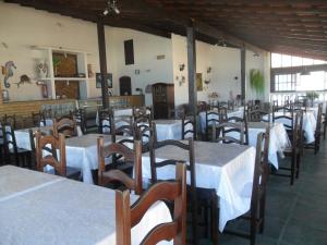 a group of tables and chairs in a restaurant at Pousada Pratagy in Saquarema