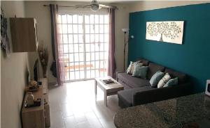 エル・メダノにあるAlmi Cabezo appartamento con terrazza El Médanoの青い壁のリビングルーム(ソファ付)