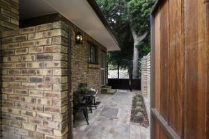 a brick house with a patio with a table at Stellenhaus Guest Cottage in Stellenbosch