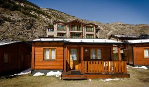 a wooden cabin in front of a mountain at Camping - Bungalows Janramon in Canillo