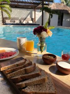 a table with a tray of bread and a plate of orange juice at Howlita Tulum - Adult Only in Tulum