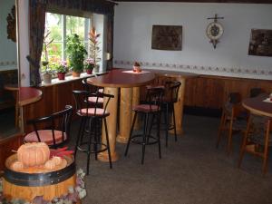 a bar in a restaurant with stools and a table at Hotel-Restaurant Zum Dorfkrug in Winterberg