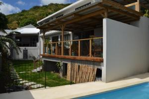 a house with a deck and a swimming pool at 21LG Le Petit Morne in La Gaulette