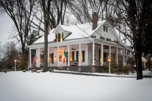 a white house with snow on the ground at Caldwell House Bed and Breakfast in Salisbury Mills