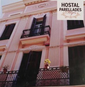 un edificio con balcones y una señal que lee milagros de hospital en Hostal Parellades, en Sitges