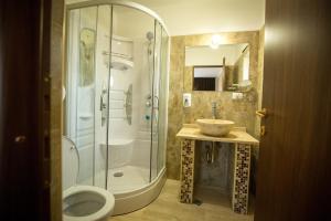 ein Bad mit einer Dusche, einem WC und einem Waschbecken in der Unterkunft MBI Travel Inn in Craiova