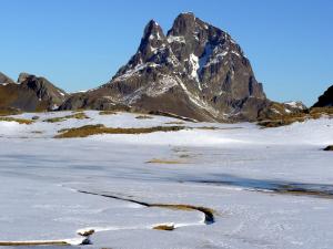 uma montanha à distância com neve no chão em El Churrón em Larrés