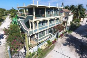 a large blue house with a balcony on a beach at BELIZE TROPICAL DREAM VILLAS in San Pedro