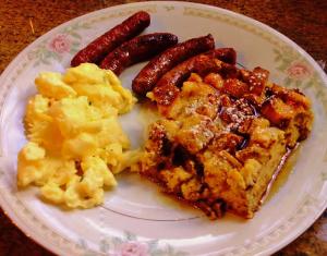 un piatto di prodotti per la colazione con salsiccia e uova di Caldwell House Bed and Breakfast a Salisbury Mills