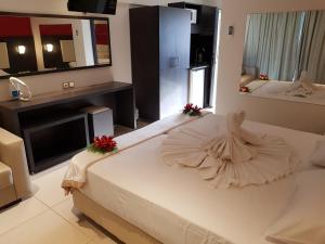ein Schlafzimmer mit einem großen Bett mit einem Kleid darauf in der Unterkunft La caretta hotel in Alikanas