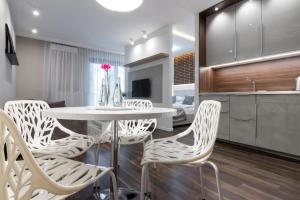 ein Esszimmer mit einem weißen Tisch und Stühlen in der Unterkunft GA Luxury Apartments W19 in Krakau