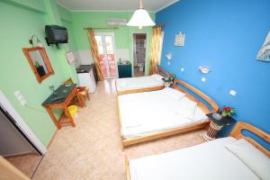 a living room with two beds and a television at Sweet Home in Karterados