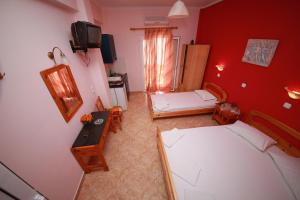 a small room with two beds and a television at Sweet Home in Karterados