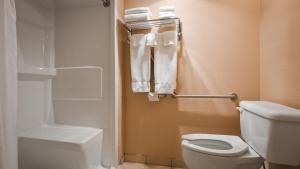 a bathroom with a toilet and a shower with towels at Best Western PLUS Mission City Lodge in Mission