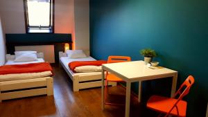 ビェルスコ・ビャワにあるHello Hostel & Apartmentsのベッド2台、テーブル、デスクが備わる客室です。 +31枚の写真