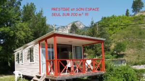 una casita roja y blanca con árboles en el fondo en Residence de Plein Air Panoramique à la Porte des Gorges du Verdon en Castellane