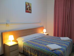 1 dormitorio con 1 cama con 2 lámparas en Hostel 3, en Milán