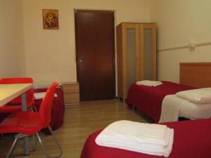 a hotel room with two beds and a table and chairs at Hostel 3 in Milan