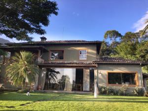une maison avec un palmier devant dans l'établissement Pousada Casa das Fontes, à Tiradentes