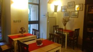uma sala de jantar com duas mesas e uma mesa e cadeiras em Citta Giardino B&B em Roma