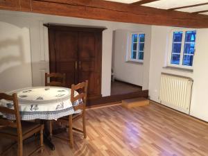 ein Zimmer mit Tisch und Stühlen und einer Tür in der Unterkunft Quartier vert in Hunspach