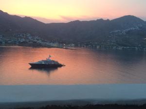 a boat in the middle of a lake at sunset at Astrio Suites in Livadi