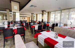 a restaurant with red and white tables and chairs at Hotel AVALON in Nesebar