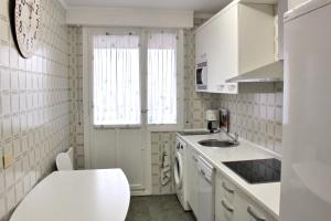 a small kitchen with white cabinets and a sink at Pension Mayte in Pamplona