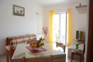 a living room with a table with a bowl of fruit on it at Apartment Dakic in Herceg-Novi