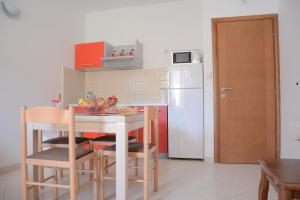 a kitchen with a table and a white refrigerator at Apartment Dakic in Herceg-Novi