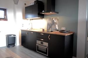 uma cozinha com armários pretos e um lavatório em Kappeberg Lodge em Winterberg
