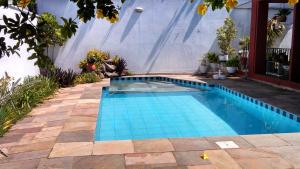 a swimming pool with blue tiles in a yard at Comodita in São Paulo