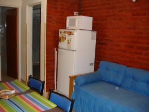 sala de estar con sofá azul y nevera en Glaniad Apartments, en Puerto Madryn