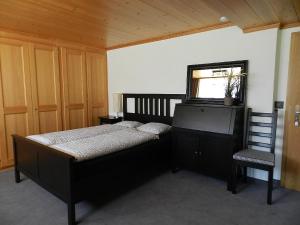 1 dormitorio con 1 cama, 1 silla y 1 ventana en Apartment Bijou Arnensee by Interhome, en Gsteig