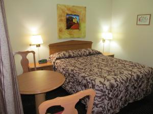 a hotel room with a bed and a table at Knights Inn London Ontario in London