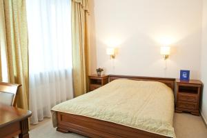 a bedroom with a bed and two dressers and a window at Kolonna Hotel Brigita in Riga