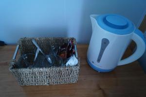 a basket of utensils sitting next to a mug at Mangata Hotel Low Cost in Castro