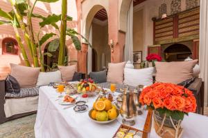 a table with fruit and flowers on it at Indian Palace in Marrakesh