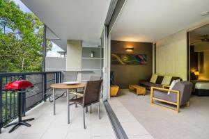 a room with a balcony with a table and chairs at Perfect luxury for 2, Noosa Heads in Noosa Heads