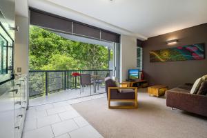 a living room with a couch and a balcony at Perfect luxury for 2, Noosa Heads in Noosa Heads